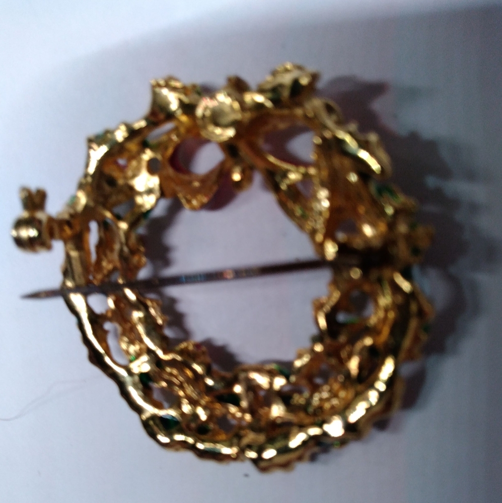 Christmas tree wreath brooch unmarked is red green and gold with a red bow.